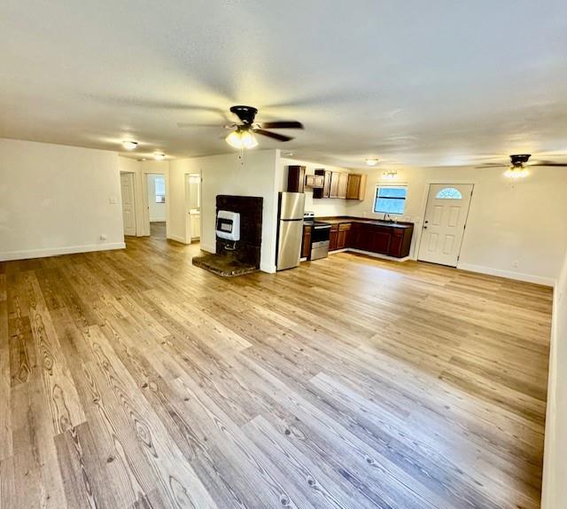 unfurnished living room with a wood stove and light hardwood / wood-style floors