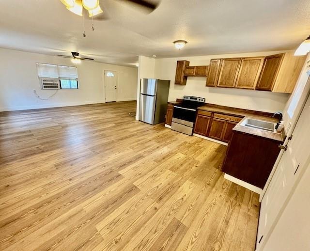 kitchen featuring stainless steel appliances, ceiling fan, light hardwood / wood-style floors, and sink