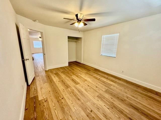 unfurnished bedroom with light wood-type flooring, a closet, and ceiling fan