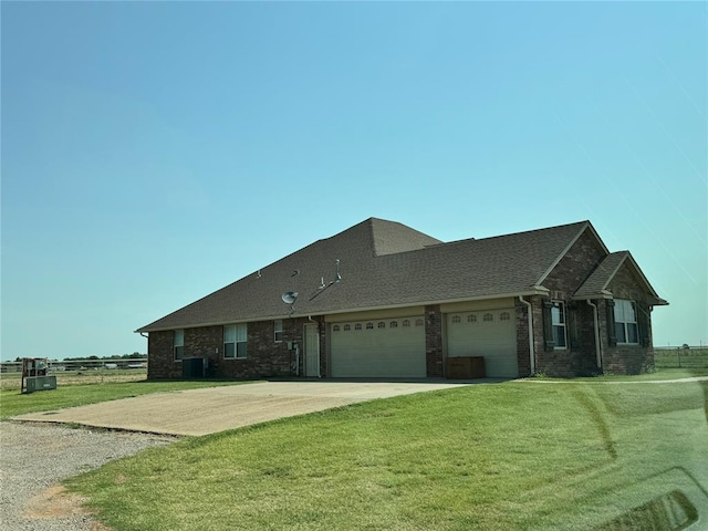 view of front of property featuring central AC unit, a front yard, and a garage