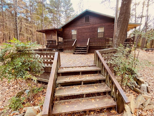 rear view of house featuring a wooden deck