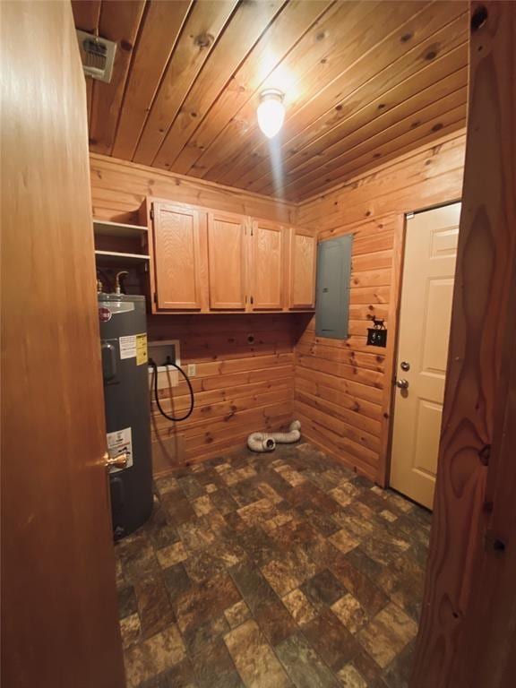 clothes washing area featuring cabinets, washer hookup, water heater, electric panel, and wooden walls