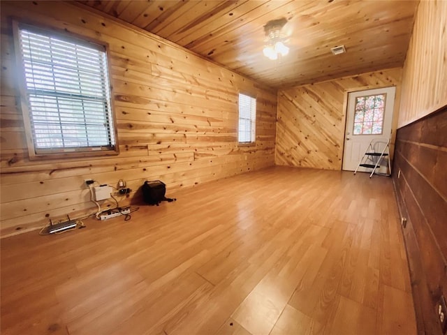 additional living space with wooden ceiling, hardwood / wood-style flooring, and wooden walls