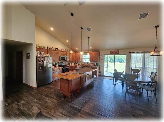 kitchen featuring stainless steel appliances, high vaulted ceiling, dark hardwood / wood-style floors, pendant lighting, and a kitchen island