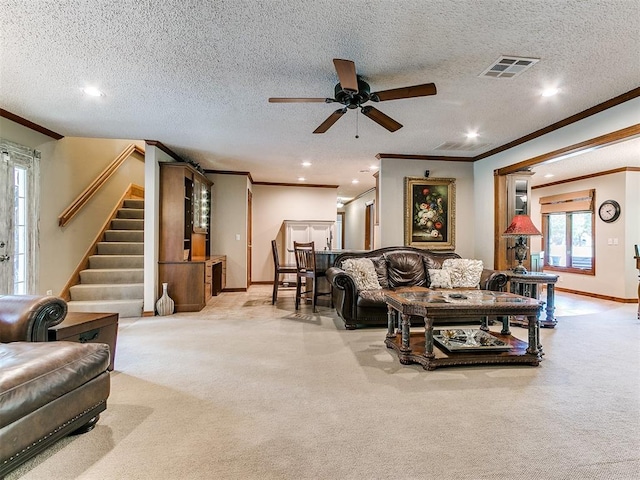 carpeted living room with ceiling fan, crown molding, and a textured ceiling