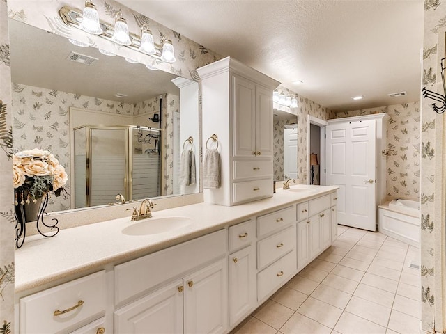 bathroom with tile patterned floors, vanity, separate shower and tub, and a textured ceiling