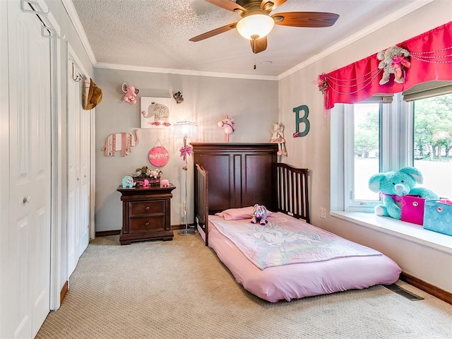 carpeted bedroom featuring ceiling fan, a closet, a textured ceiling, and ornamental molding