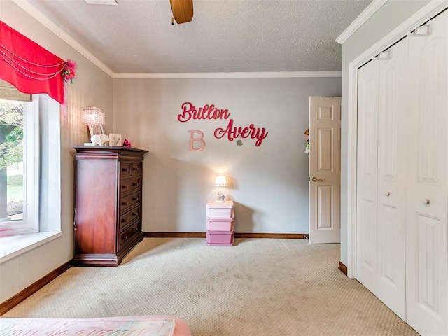 unfurnished bedroom with ceiling fan, light colored carpet, a textured ceiling, a closet, and ornamental molding