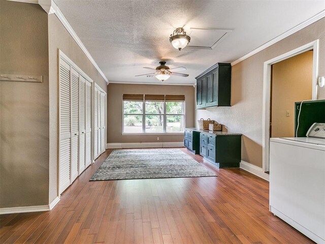 interior space featuring hardwood / wood-style floors, ornamental molding, a textured ceiling, and washer / dryer