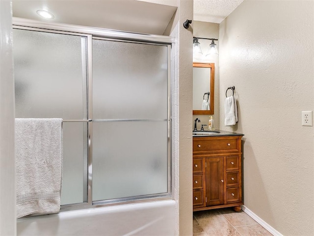 bathroom with tile patterned flooring, vanity, and bath / shower combo with glass door