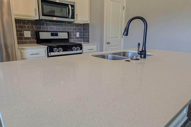 kitchen with backsplash, black stove, and sink