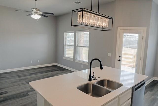 kitchen with sink, hanging light fixtures, stainless steel dishwasher, dark hardwood / wood-style floors, and an island with sink