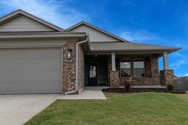 view of front of house featuring a porch, a garage, and a front yard