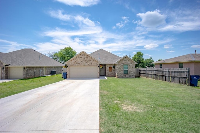 view of front of home with a front lawn, central AC unit, and a garage