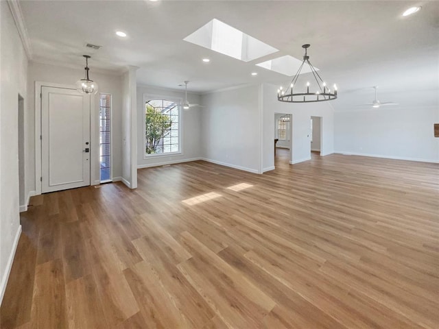 unfurnished living room with ceiling fan with notable chandelier, light wood-type flooring, and crown molding