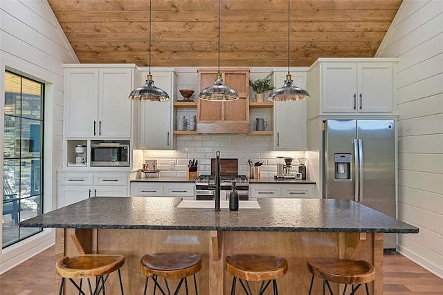 kitchen featuring a healthy amount of sunlight, white cabinetry, and an island with sink