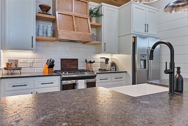 kitchen featuring stainless steel gas stove, white cabinetry, and backsplash