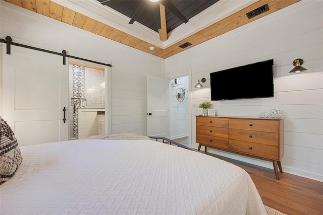 bedroom featuring ensuite bathroom, ceiling fan, a barn door, hardwood / wood-style flooring, and wooden ceiling