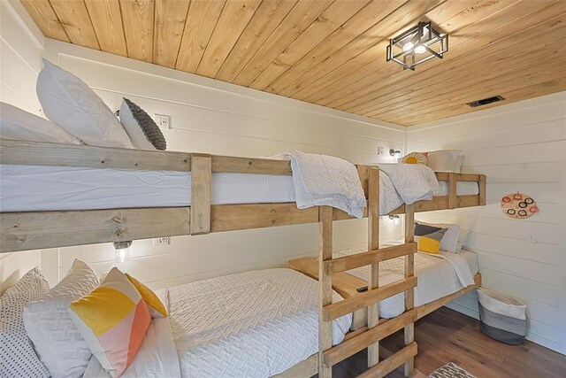 bedroom featuring hardwood / wood-style floors, wooden ceiling, and wood walls