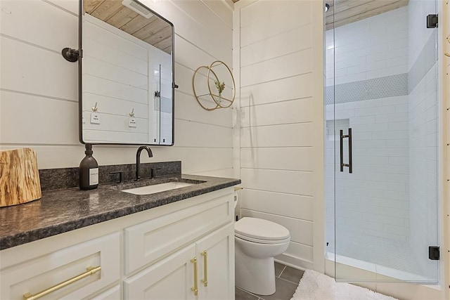 bathroom featuring tile patterned floors, an enclosed shower, vanity, wooden walls, and toilet