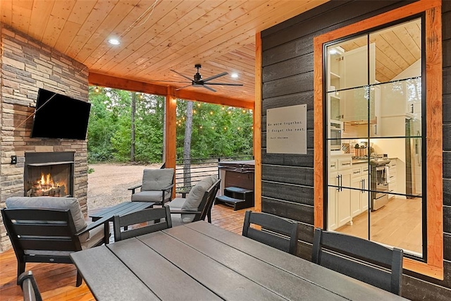 view of patio featuring an outdoor stone fireplace and ceiling fan