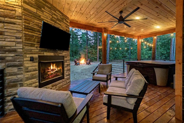 wooden terrace featuring ceiling fan and an outdoor stone fireplace