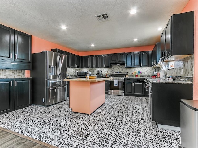 kitchen with a center island, sink, appliances with stainless steel finishes, and tasteful backsplash