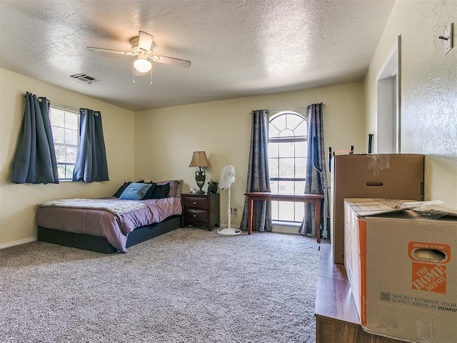 bedroom featuring ceiling fan, carpet floors, and a textured ceiling