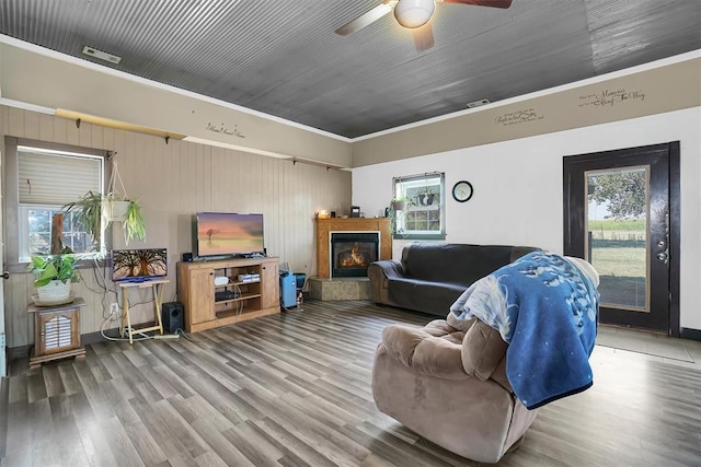 living room featuring crown molding, plenty of natural light, ceiling fan, and wood-type flooring