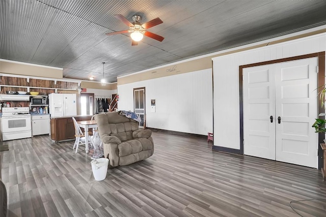 living room featuring ceiling fan, dark hardwood / wood-style flooring, and crown molding