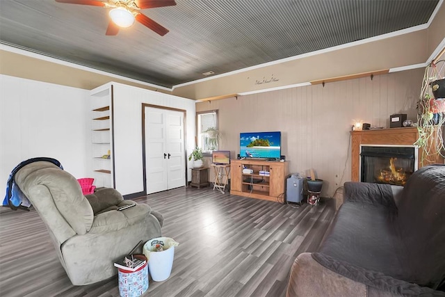 living room featuring dark hardwood / wood-style flooring, ceiling fan, and crown molding