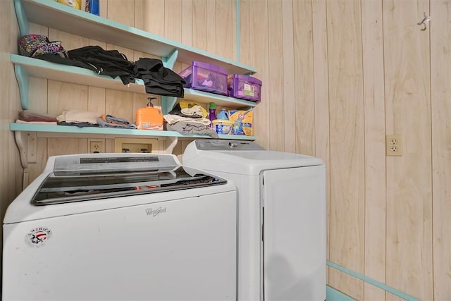 laundry area featuring washer and clothes dryer and wooden walls