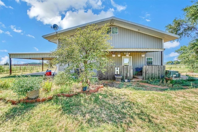 rear view of house with a lawn and central AC unit