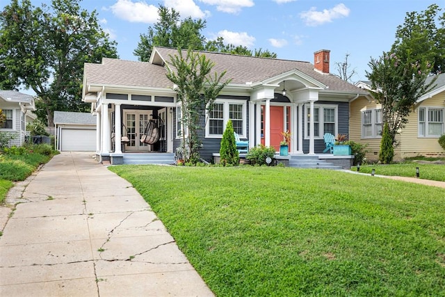 view of front of house with an outbuilding, a front yard, and a garage