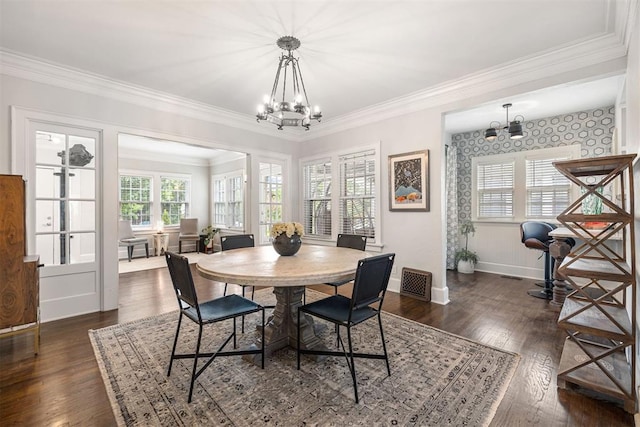 dining area with dark hardwood / wood-style floors, an inviting chandelier, and crown molding