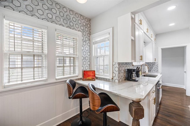 kitchen featuring plenty of natural light, sink, and a breakfast bar area