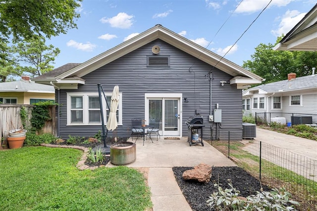 rear view of house with a patio area, a yard, and central AC