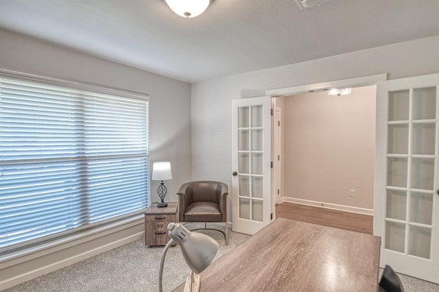 carpeted home office with french doors