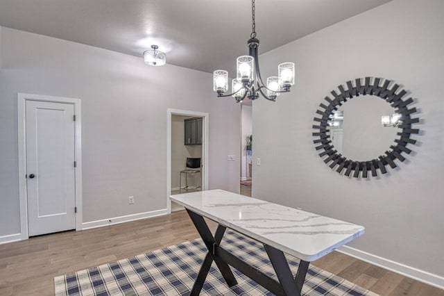 dining space featuring light hardwood / wood-style floors and an inviting chandelier