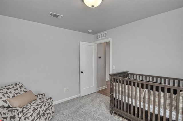 bedroom with carpet and a crib