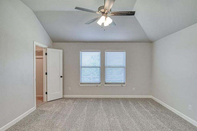 carpeted spare room with ceiling fan and lofted ceiling