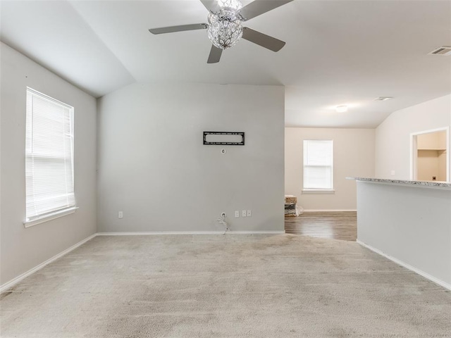 unfurnished room featuring ceiling fan, light colored carpet, and lofted ceiling