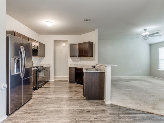 kitchen featuring dark brown cabinets, black gas range, sink, light hardwood / wood-style flooring, and stainless steel fridge with ice dispenser