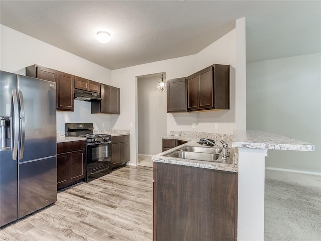 kitchen with a breakfast bar, sink, kitchen peninsula, black gas range oven, and stainless steel fridge with ice dispenser