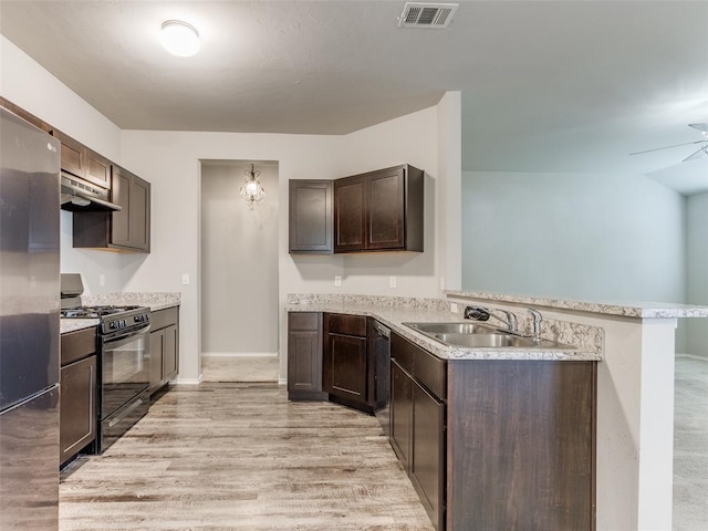 kitchen with kitchen peninsula, light wood-type flooring, dark brown cabinets, sink, and black gas range