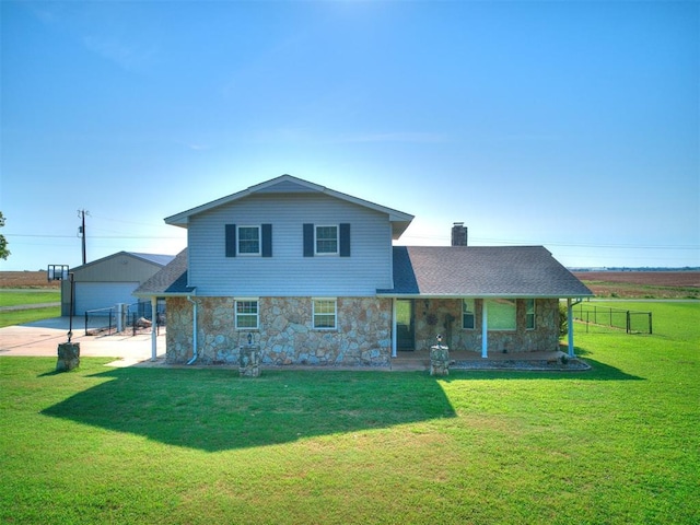 view of front of house featuring an outdoor structure, a front yard, and a garage