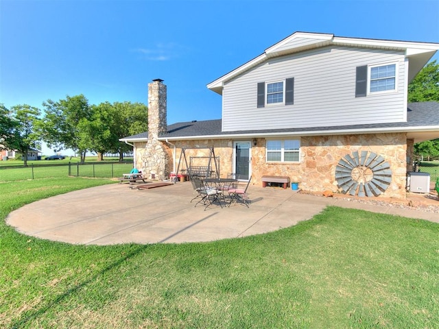 rear view of house featuring a yard and a patio