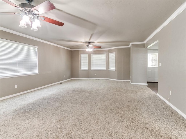 unfurnished room with carpet flooring, a wealth of natural light, and crown molding