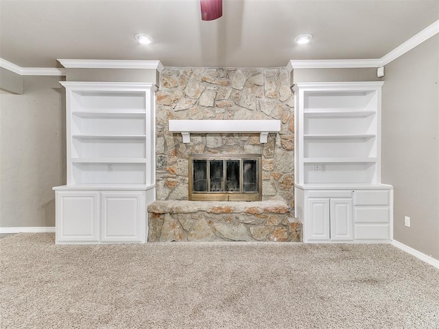 unfurnished living room featuring crown molding, ceiling fan, built in features, a fireplace, and carpet floors