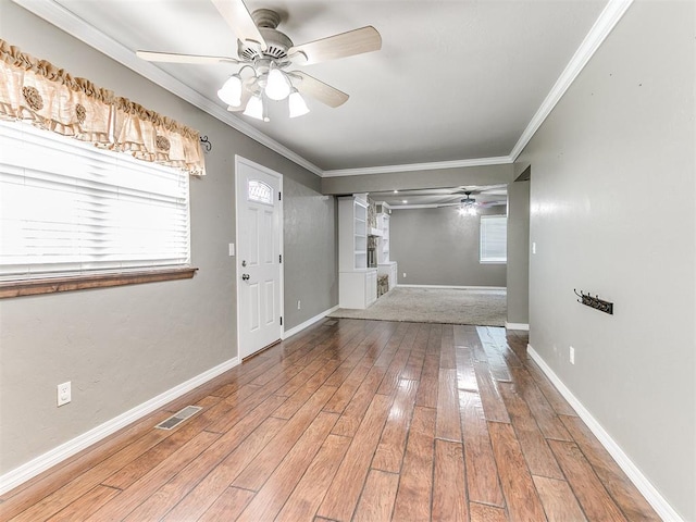 foyer entrance featuring hardwood / wood-style flooring, ceiling fan, and crown molding